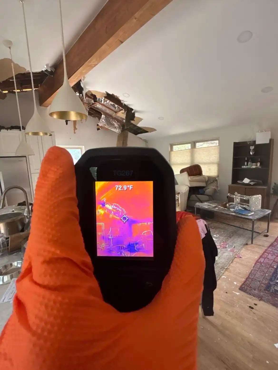 Thermal imaging camera held up toward a living room ceiling